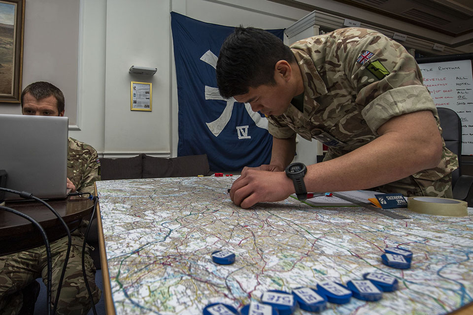 A British Army soldier moves markers across a map