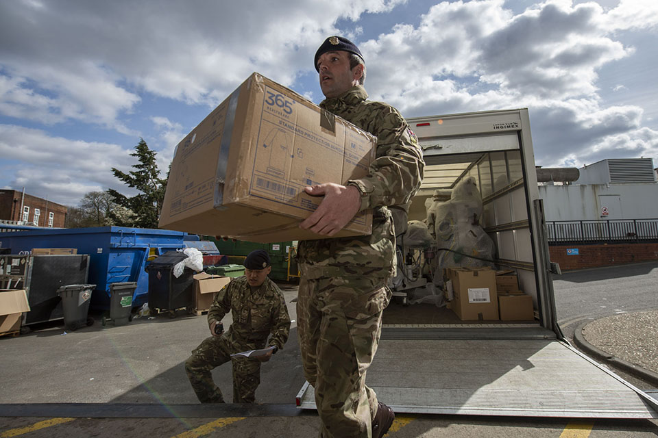 A British Army soldier carries a box from a lorry