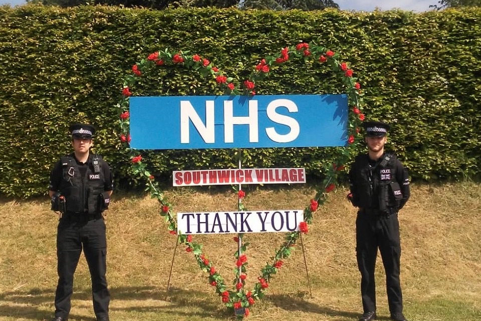Image shows two police officers next to a handmade message of thanks to the NHS from the community at Southwick. 