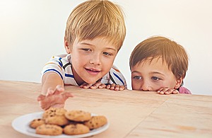 Children reaching for biscuits