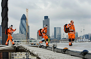Air ambulance paramedics walking across a rooftop with London skyline behind