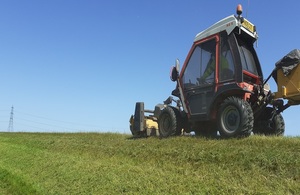 Picture shows grass being cut along the Middle Level Barrier Bank