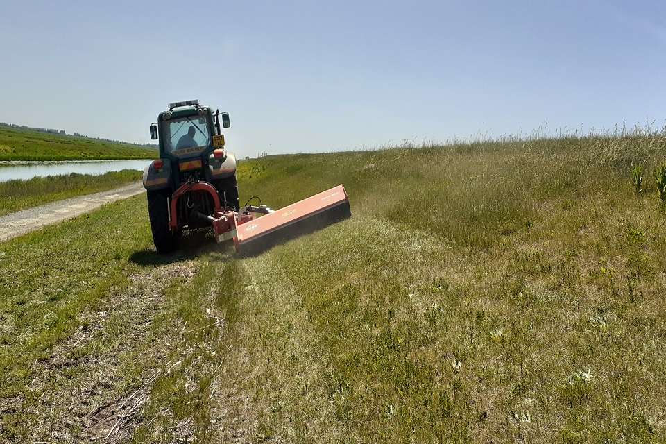 Picture shows grass being cut along the Middle Level Barrier Bank