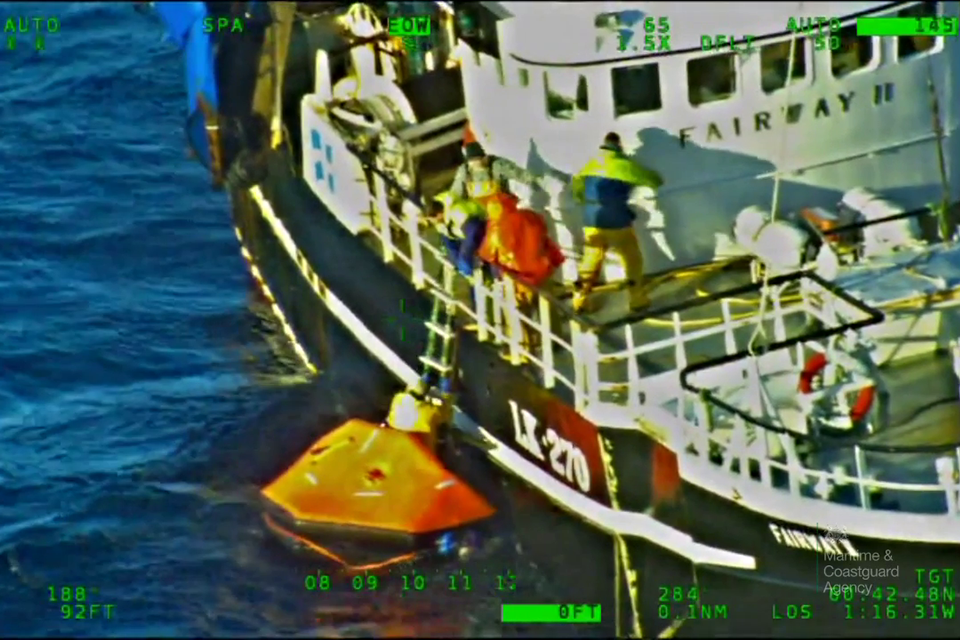 Crew being recovered from liferaft onto another fishing vessel.