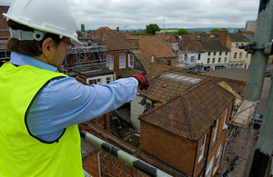 Man in a hardhat surveying a building