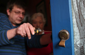 Man fitting a lock to a door
