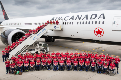Invictus Games UK Team posing in front of an Air Canada plane at London Heathrow.