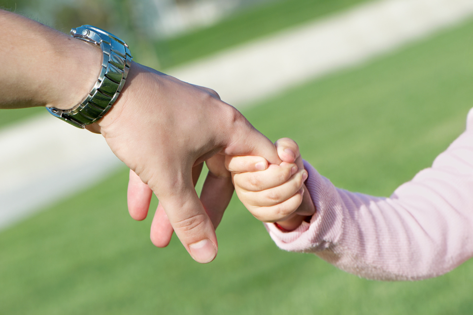 Child's hand holding an adult's hand