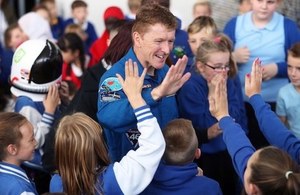 Tim Peake high-fives young people in the audience at Cardiff post-flight tour event.