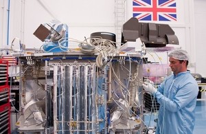 Engineer working on space technology in clean room.