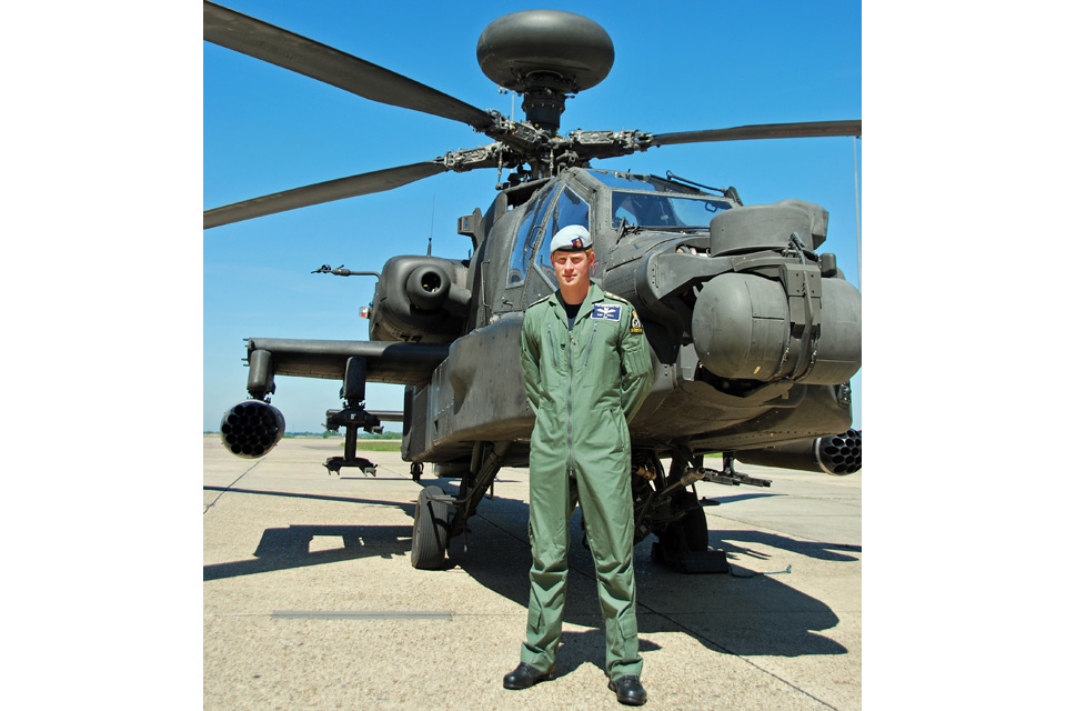 Captain Harry Wales standing in front of a British Army Apache attack helicopter