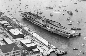 Aerial view of the aircraft carrier HMS Hermes, about to berth alongside at Portsmouth Harbour on her return from the Falklands on 21 July 1982 [Picture: Crown copyright - IWM (FKD 684)]