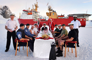 Crew members of HMS Protector sit down to their Christmas dinner on the ice [Picture: Leading Airman (Photographer) Vicki Benwell, Crown copyright]