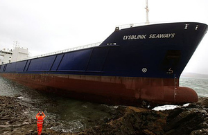 Photograph showing cargo vessel Lysblink Seaways aground on the rocky foreshore.