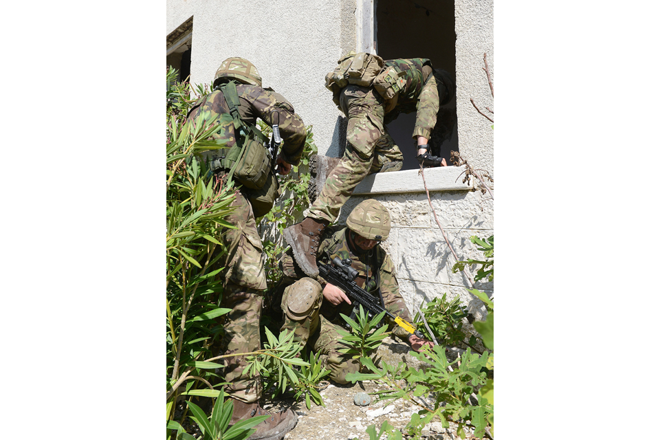 Royal Marines enter a building through a window