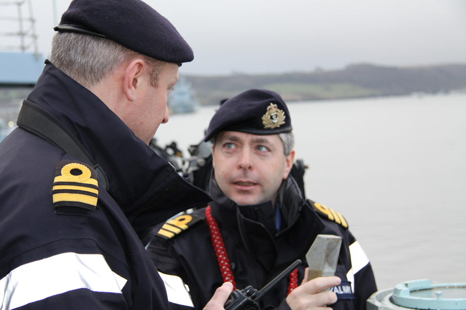 Commander Mike Smith speaks with a lieutenant commander on the ship's deck