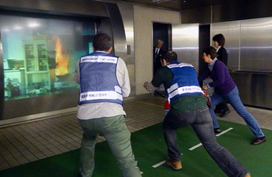 ‘kaji da!’ Participants practice putting out fires at Tachikawa Life Safety Learning Center