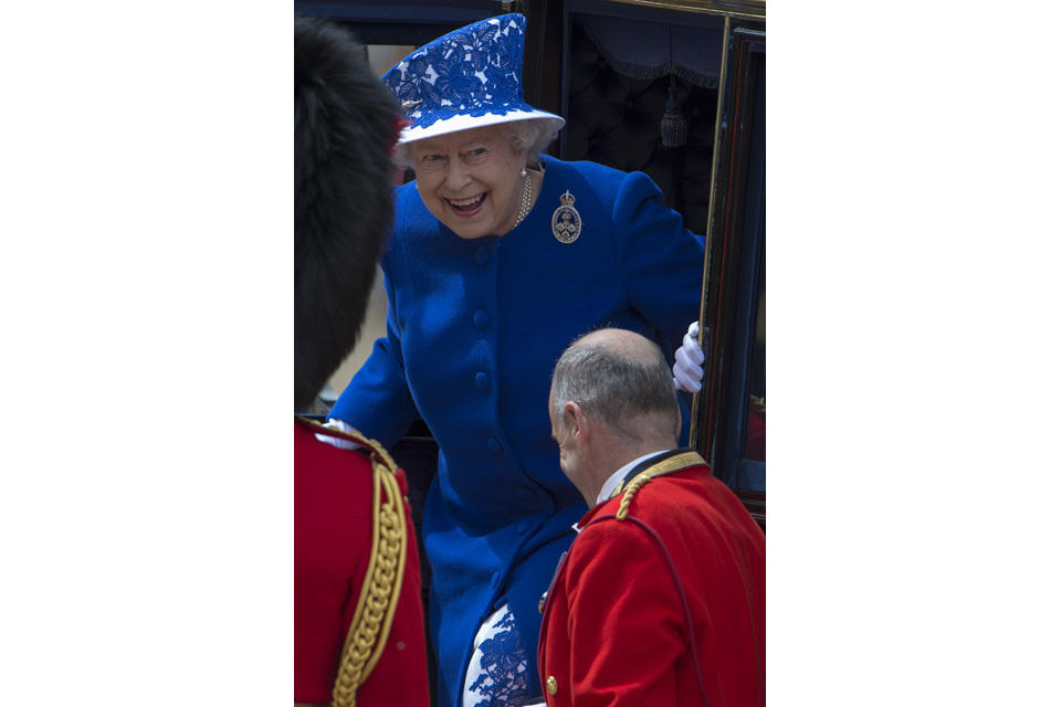 Her Majesty The Queen smiles as she steps from her carriage