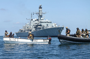 Royal Marines and Royal Navy sailors from HMS Montrose investigate a boat with suspected pirates onboard