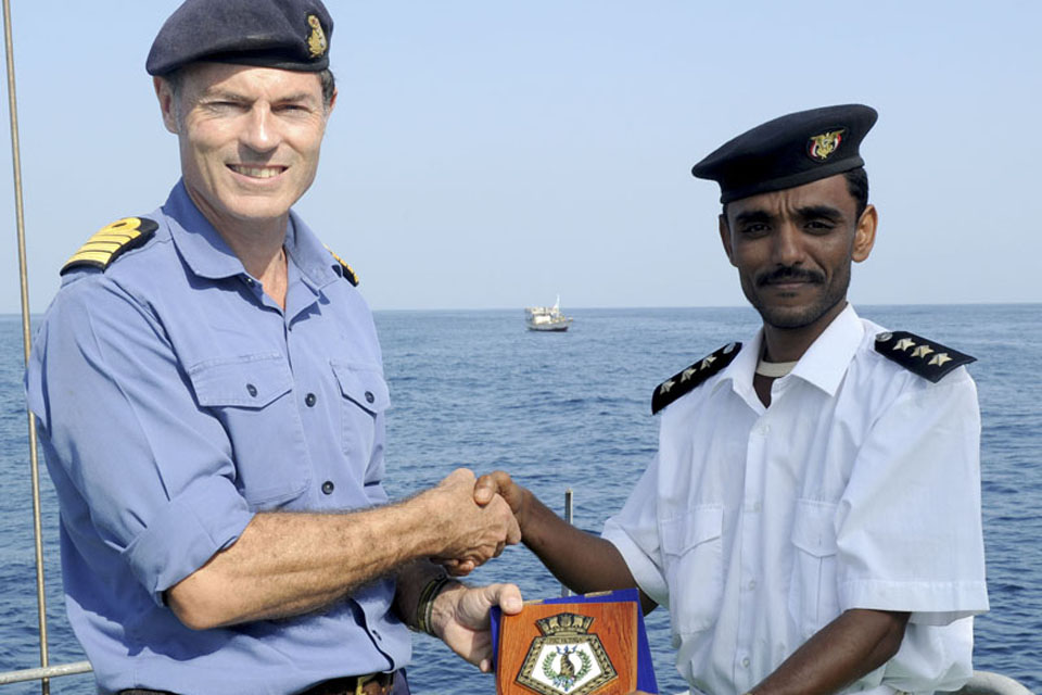 Captain Gerry Northwood presents a plaque to the captain of Yemeni Navy ship 1031 