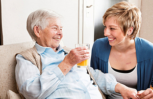 A carer spending time with an elderly woman
