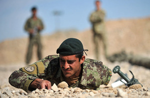 British Army explosive ordnance disposal trainers watch an Afghan soldier conducting search drills