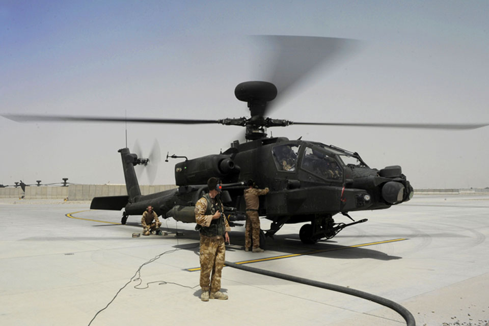 Ground crew check over a British Army Apache attack helicopter