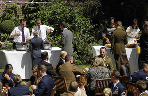 Prime Minister David Cameron, US President Barack Obama, and their wives - Samantha Cameron and First Lady Michelle Obama - serve food to members of the military from the UK and the US during a barbecue in the garden of 10 Downing Street