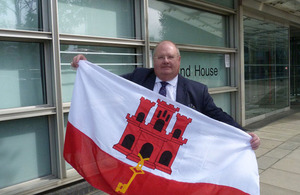 Eric Pickles with the Flag of Gibraltar outside the Department for Communities and Local Government.