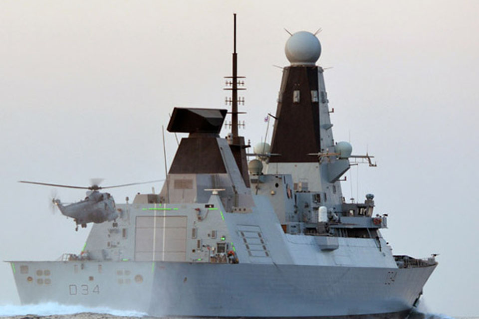 Green LED lights illuminate HMS Diamond's hangar structure to guide the helicopter in to land