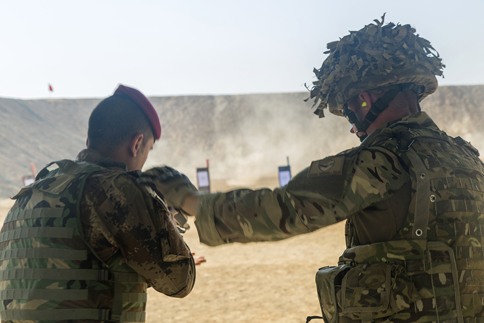 A British soldier helps an Iraqi soldier adjust his stance. Combined Joint Task Force - Operation Inherent Resolve Copyright. 