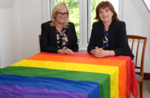 Image of Nicky Morgan MP and Caroline Dinenage MP with a rainbow flag