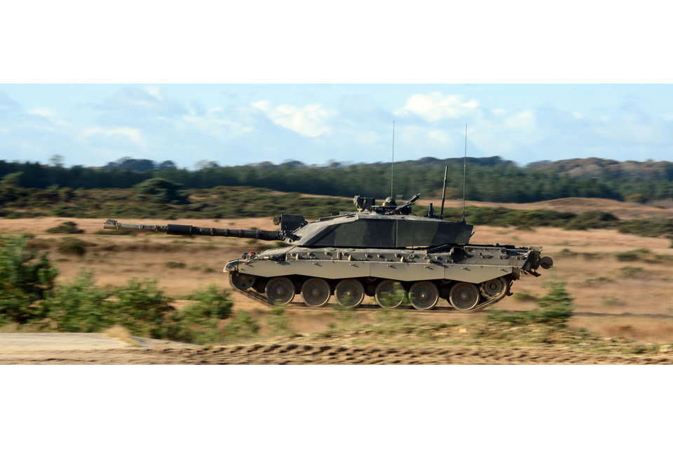 A Challenger 2 main battle tank races across the Five Tips Range