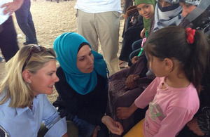 Photograph of Justine Greening talking to a refugee child in Jordan