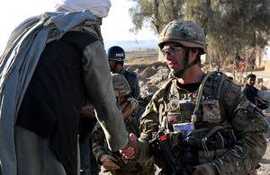 An Afghan elder greets a joint patrol of British soldiers and Afghan National Police in Lashkar Gah