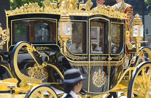 Her Majesty the Queen in a golden carriage.