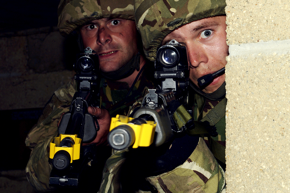 Soldiers from the London Regiment clear a building