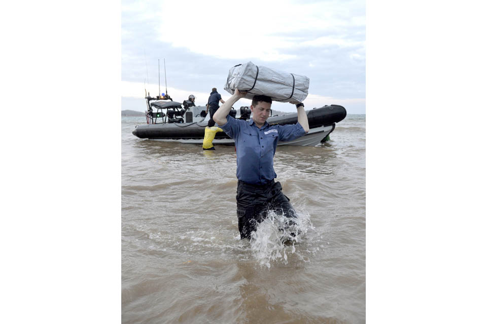 Lieutenant Commander Teilo Elliot-Smith helps with unloading prepacked shelters