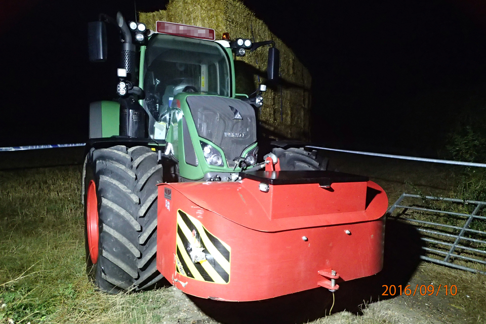 A night time view of the large green tractor involved in the accident. The train hit the red counter-weight attached to the front of the tractor.