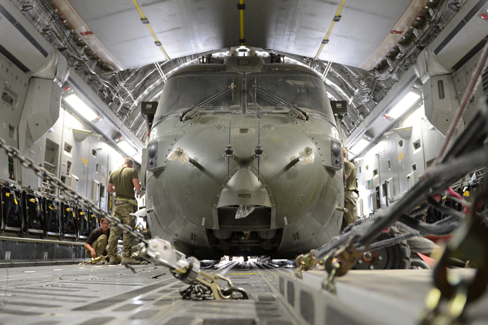 A Merlin helicopter is packed and secured into an RAF C-17 Globemaster transport aircraft