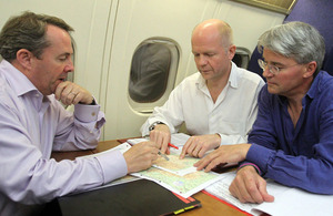 From left: Defence Secretary Dr Liam Fox, Foreign Secretary William Hague, and International Development Secretary Andrew Mitchell talking during a flight to Kabul, Afghanistan