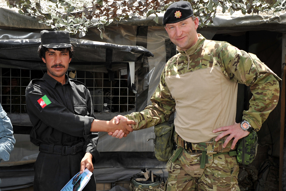 Major Kenneth Nielsen shakes hands with a member of the Afghan Uniform Police