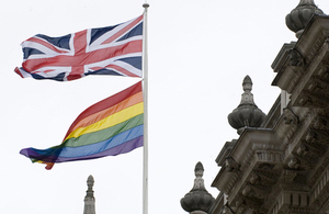 Rainbow flag and Union Jack flag on a flagpole above 70 Whitehall