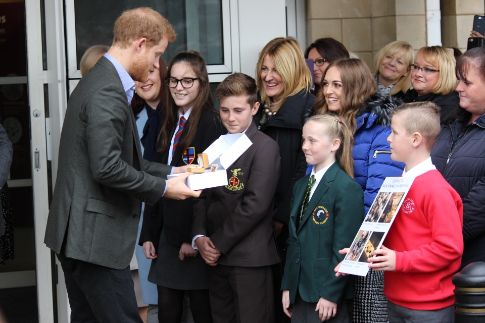 Prince Harry is presented with a Passchendaele 100 brass poppy badge by Phoebe Taylor, Crown Copyright, All Rights Reserved