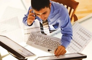 man at computer with spreadsheets