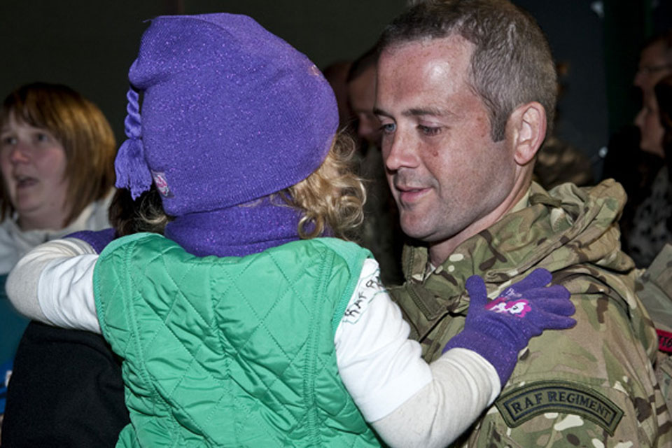A gunner from 51 Squadron RAF Regiment holds his daughter at RAF Lossiemouth
