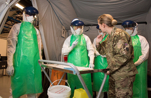 A soldier training Army reservists on how to don personal protective equipment in the fight against Ebola [Picture: Sergeant Si Longworth RLC, Crown copyright]