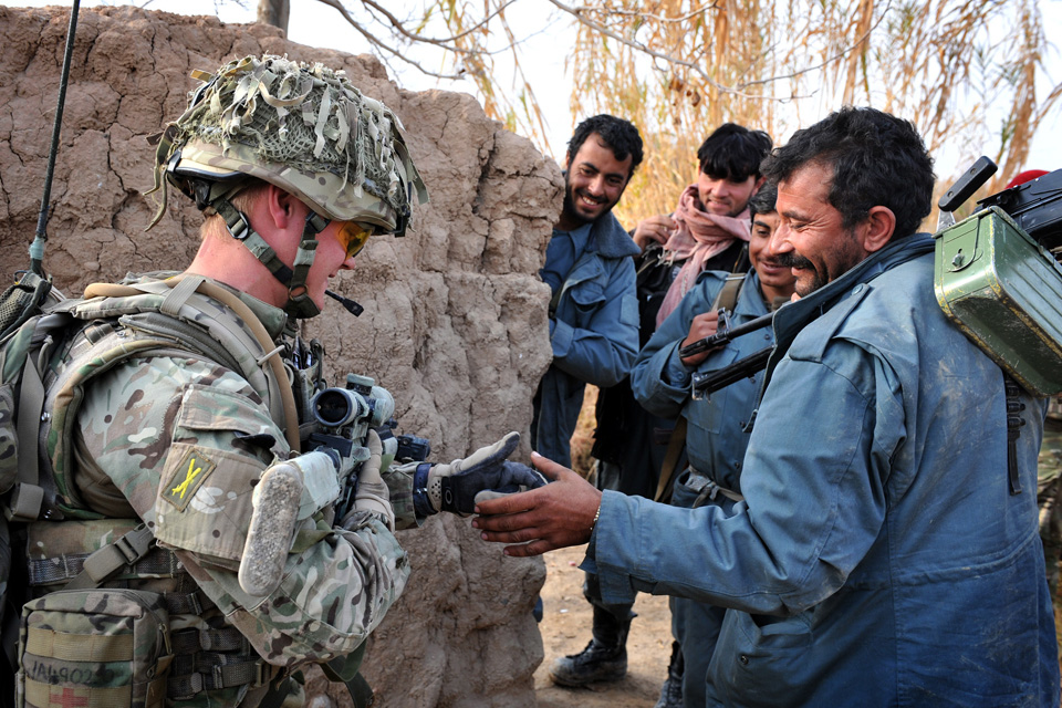 A British soldier shares a joke with members of the Afghan Uniform Police