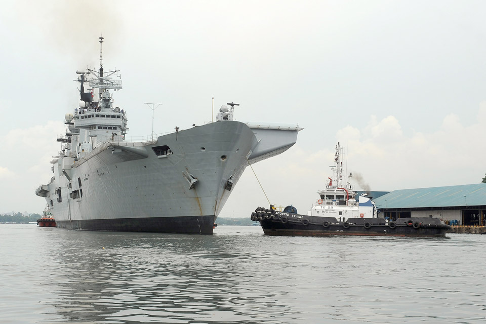 Tug boats escort HMS Illustrious safely from her berth