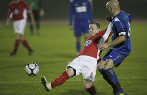 Lance Corporal Tony Fitzpatrick (in red) tackles a Sussex player in the Southern Counties Cup football competition at the Aldershot Military Stadium